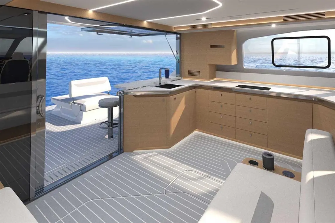 Modern yacht interior featuring a spacious kitchen, light wood cabinetry, and scenic ocean views through large windows.